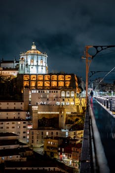 Stunning night view of Porto's architecture with illuminated buildings and a scenic overpass.