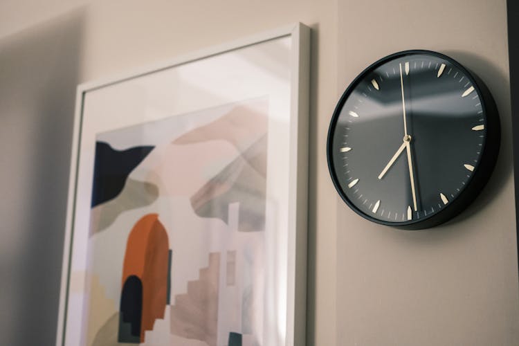 Clock And Painting Hanging On Wall