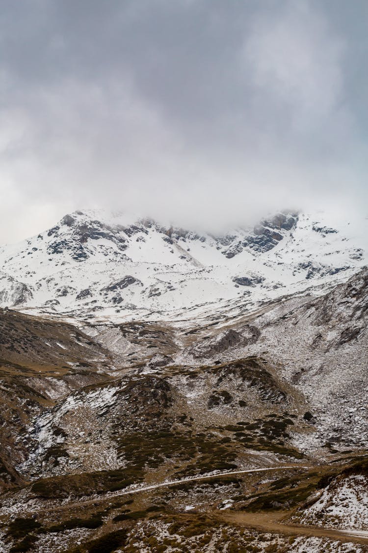 Snow Capped Mountains Under Thick Clouds