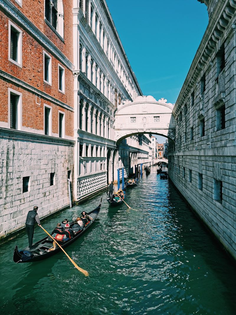 Gondolas passing beneath a Venice bridge