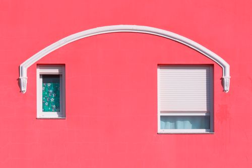 Free A striking red building facade featuring two windows and an arch, showcasing modern architecture. Stock Photo