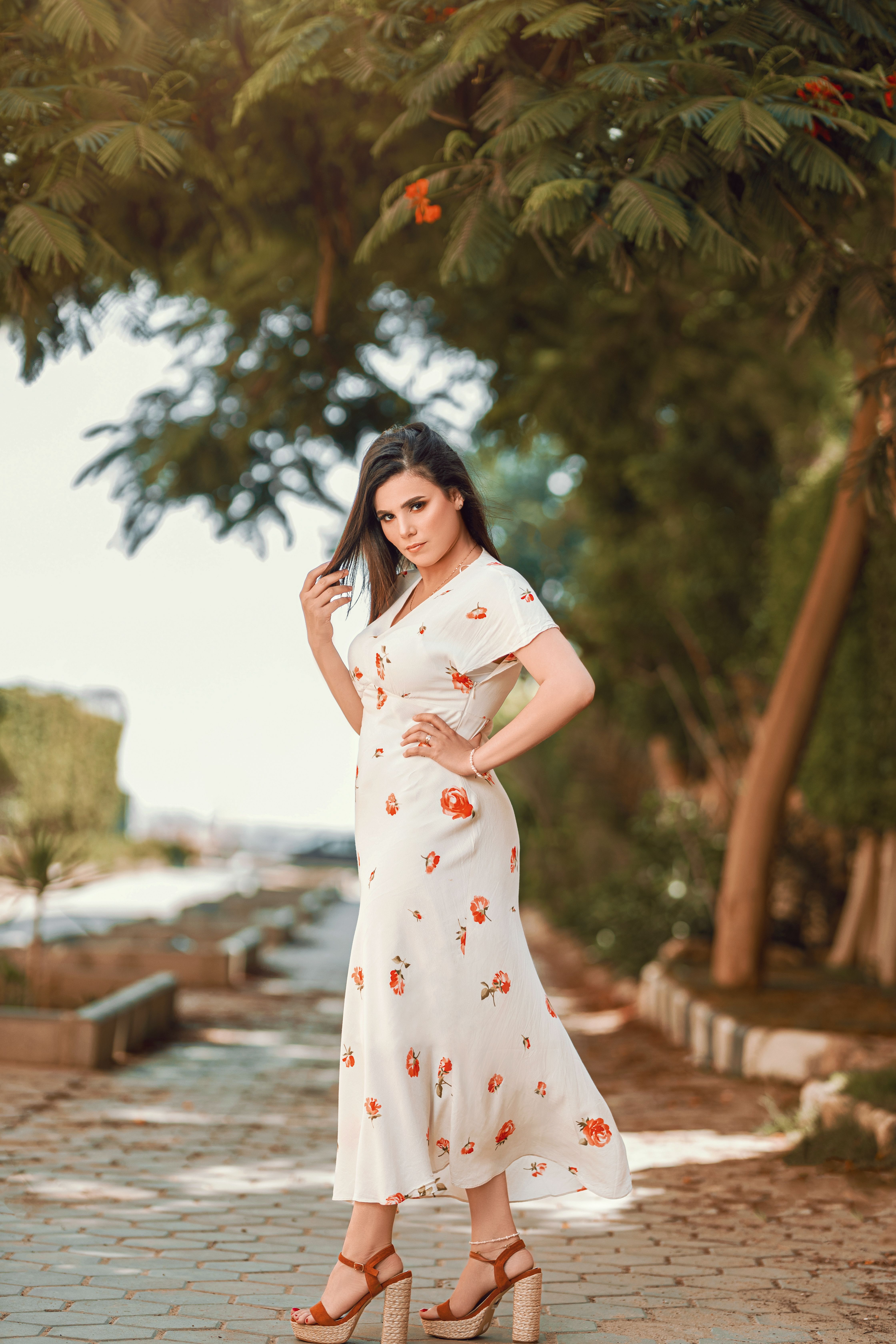 Woman in White Floral Dress Standing on Sidewalk · Free Stock Photo
