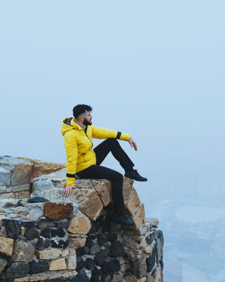 Man Sitting On A Building's Edge