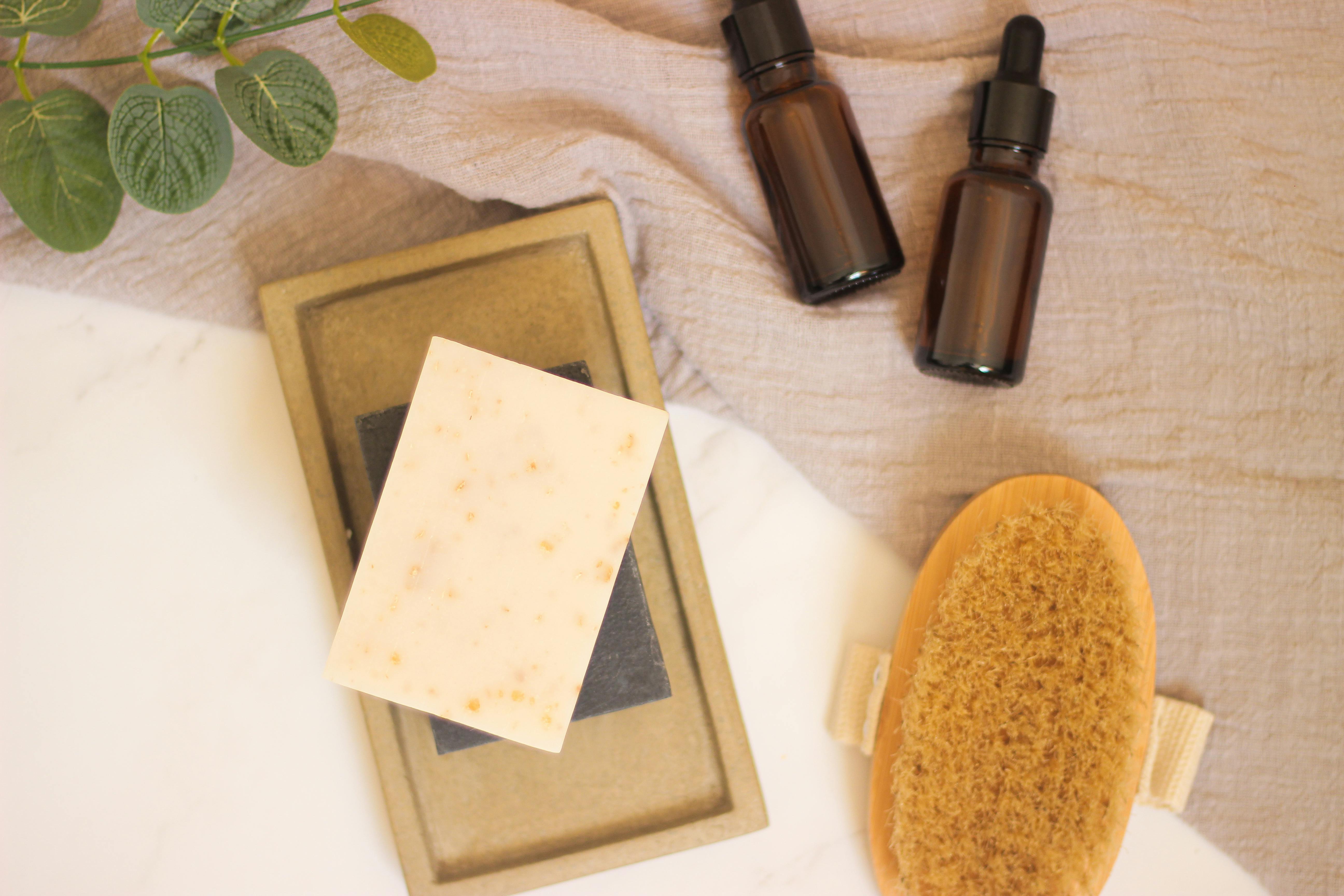 Calming spa setup featuring natural soap, essential oils, and foliage for a relaxing atmosphere.