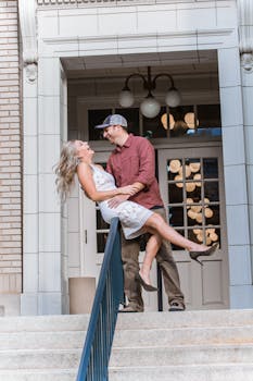 白天，一对情侣在城市楼梯上欢笑，场景浪漫