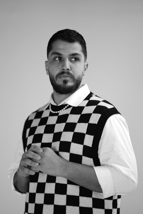 Grayscale Photo of a Man in Checkered Vest