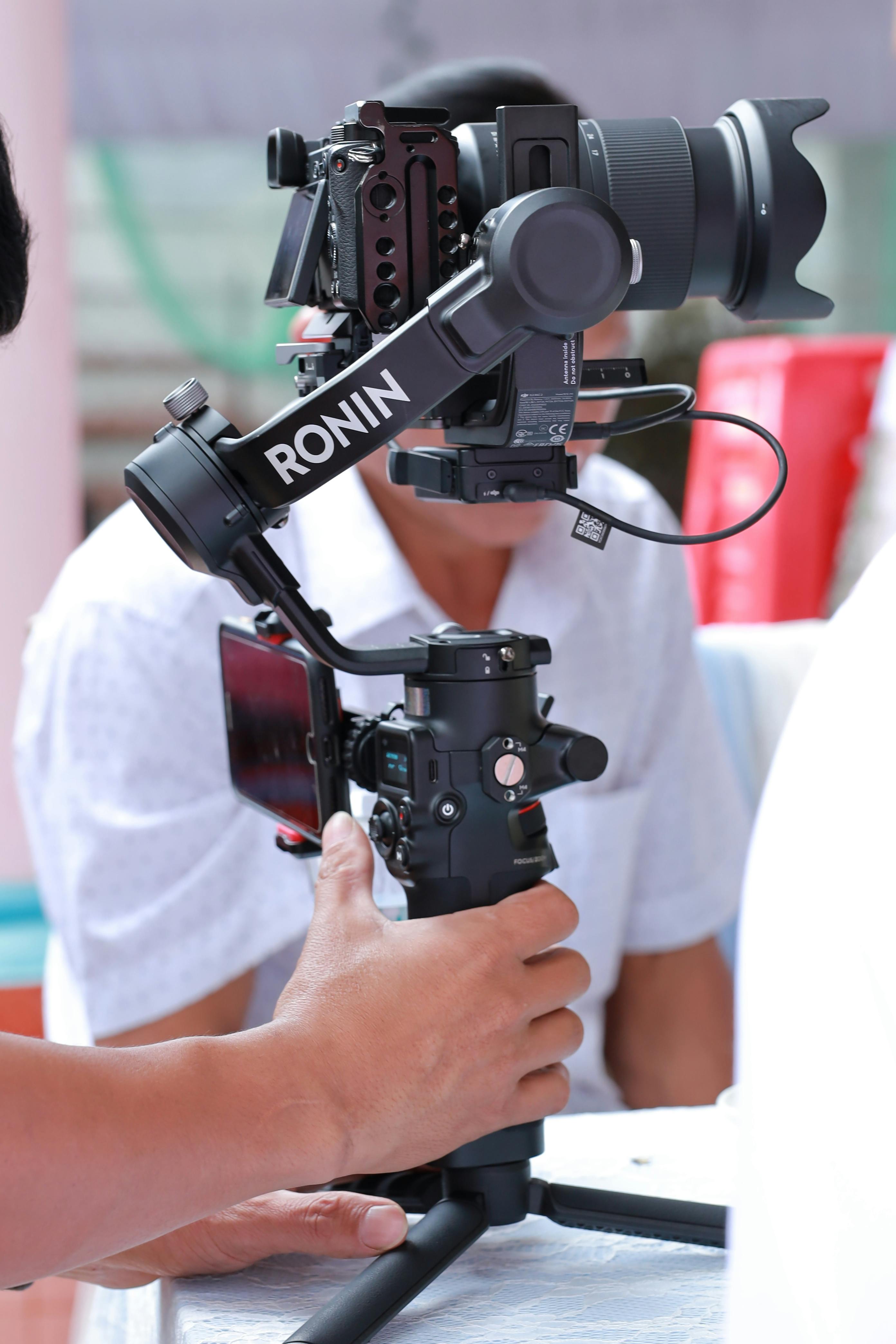 a person holding a black gimbal