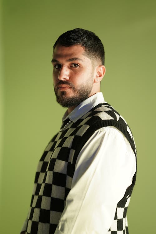 A Man in White Long Sleeves and Checkered Vest