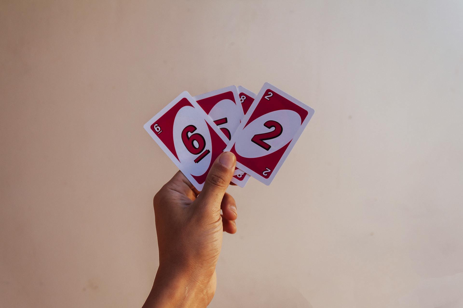 A hand holding a red card with numbers on it