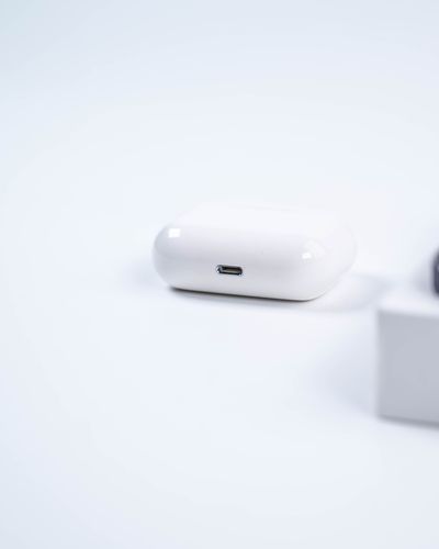 White wireless earbuds charging case on a plain background, photo by Kafeel Ahmed on Pexels