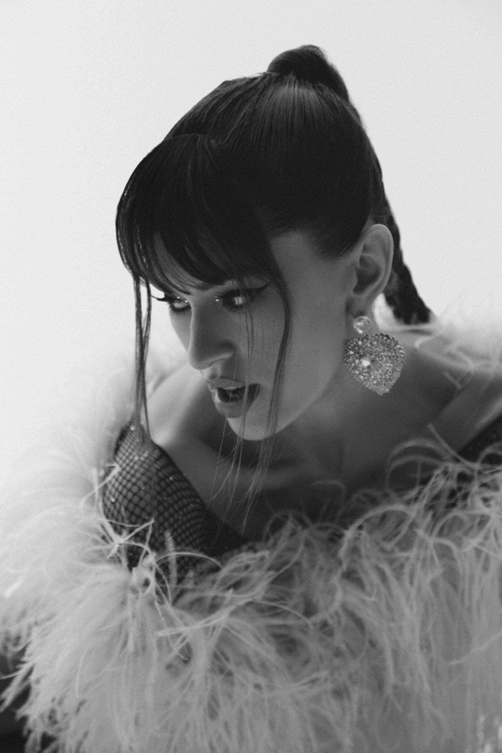 Stylish black and white portrait of a woman in glamorous attire with feather details, shot in Los Angeles.