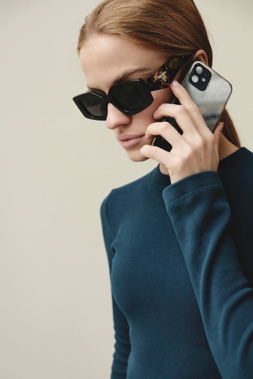 Free Young Woman in Sunglasses Talking on Modern Smartphone Stock Photo