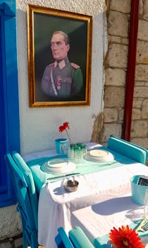Outdoor café in Izmir, Turkey with a portrait of Atatürk and stylish table setting.