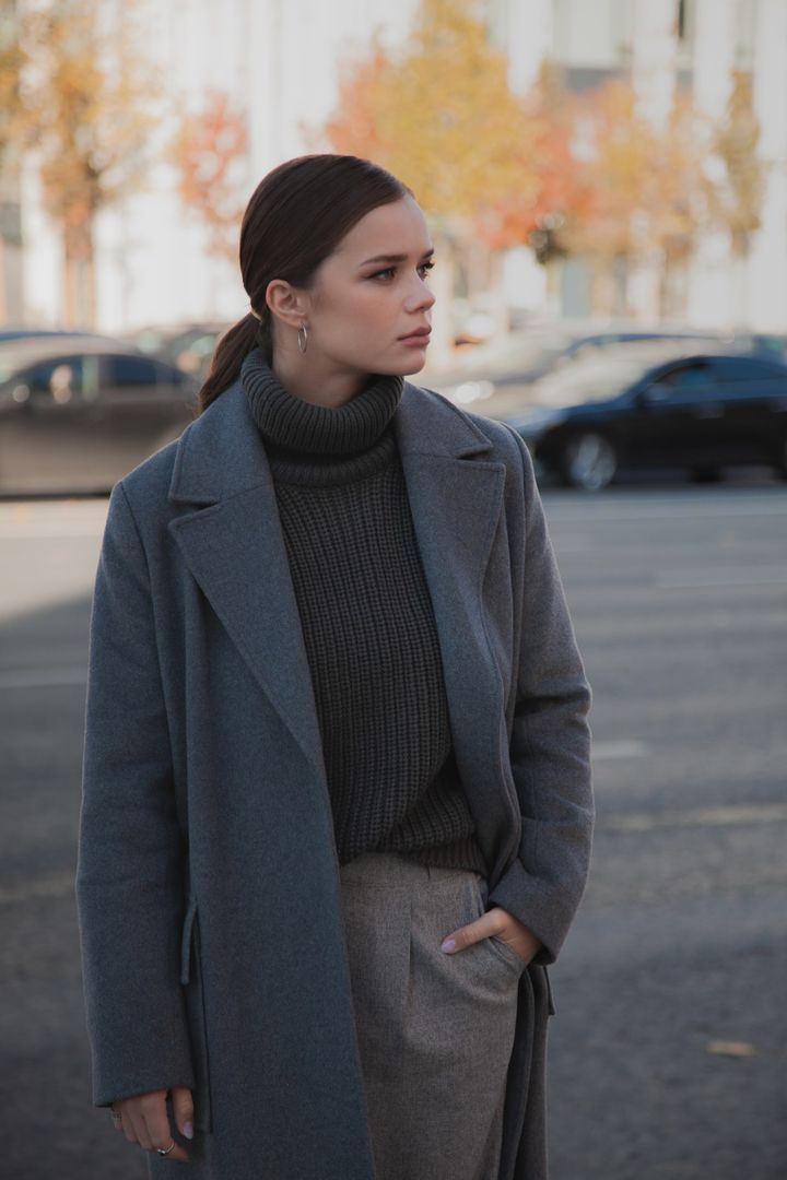 Model in a deep green long coat against concrete — photo by Vika Kirillova on Pexels
