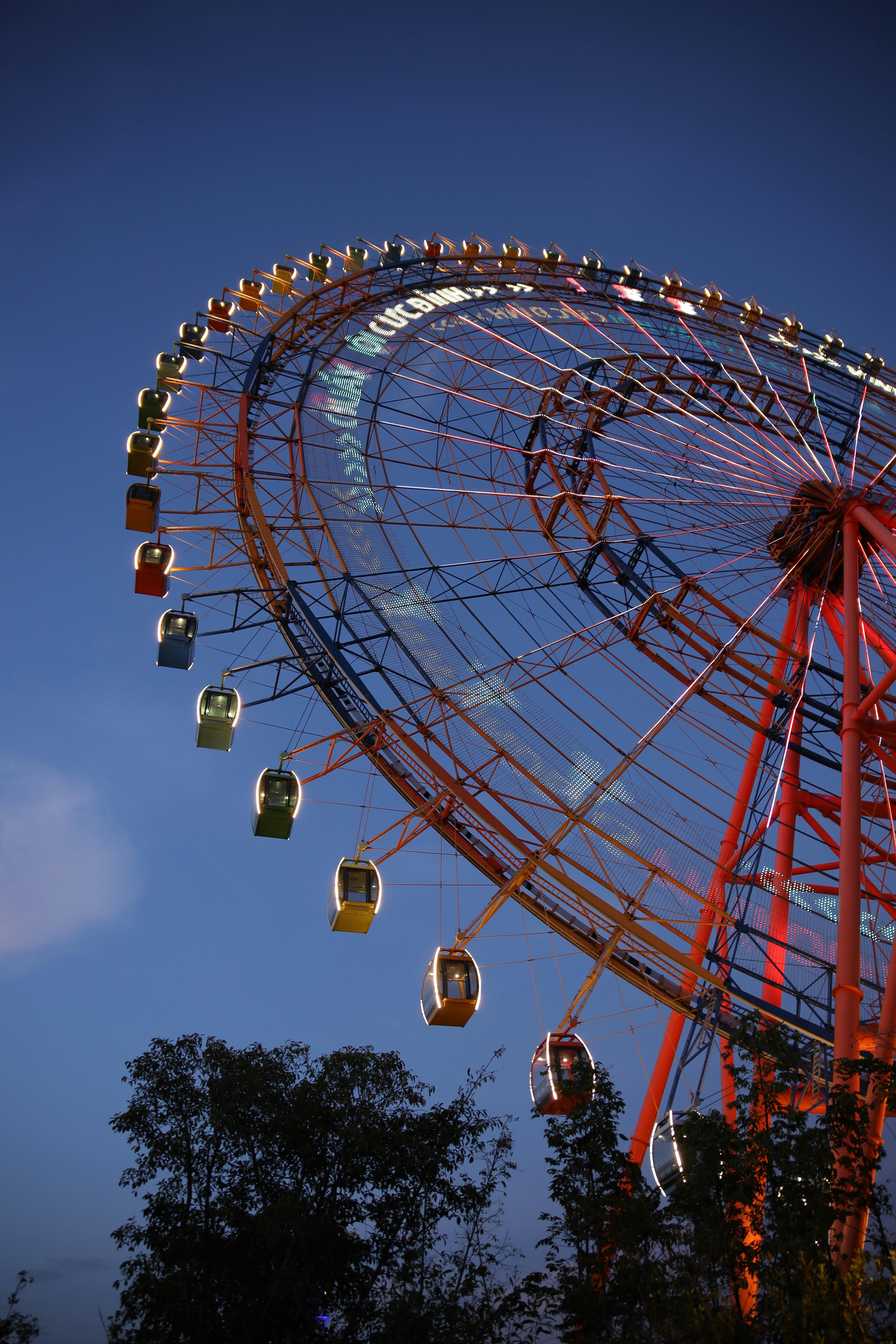 Illuminated Ferris wheel in Phu Quoc, Vietnam against a deep blue sky.