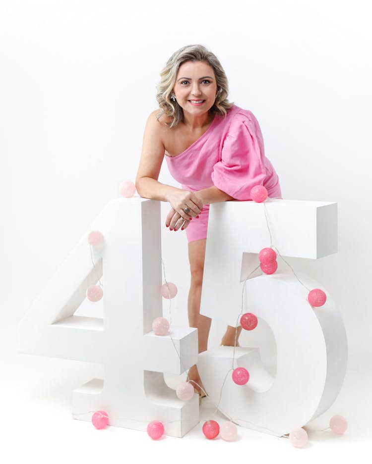 Woman In Pink Dress Posing With 45 Birthday Sign