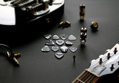 Free A detailed shot of various guitar picks and accessories arranged artistically on a black surface. Stock Photo