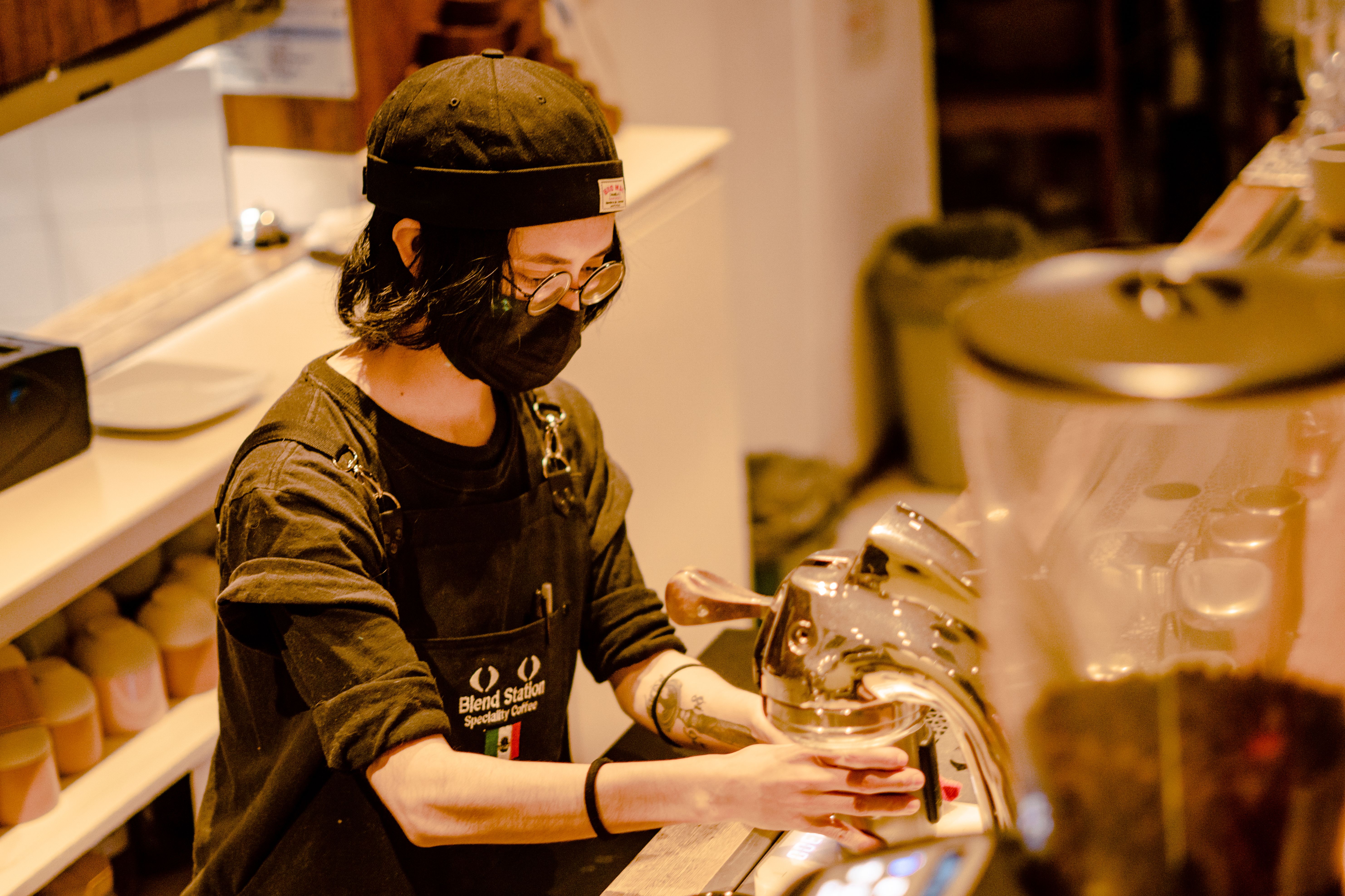 A dedicated barista expertly brews coffee in a bustling café in Mexico City.