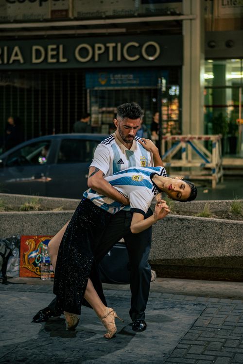 Free Couple performing Argentine Tango outdoors in Buenos Aires, showcasing cultural dance and vibrant street life. Stock Photo