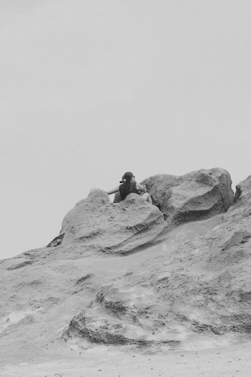 Woman Sitting Among Rocks in Black and White
