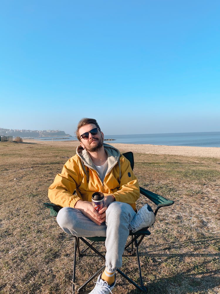 Man Sitting In A Chair On A Beach 