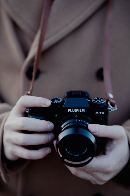 Free Focused shot of hands holding a camera outdoors, emphasizing photography essentials. Stock Photo