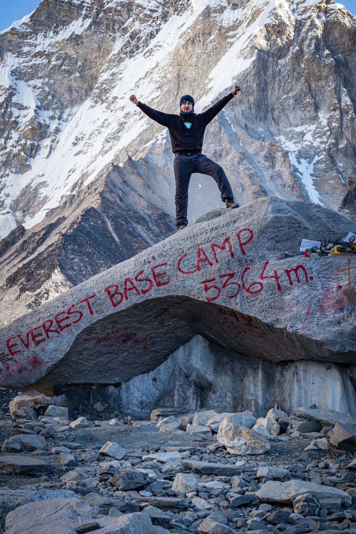 Trekker standing at Everest Base Camp Nepal at 5364 metres altitude sign