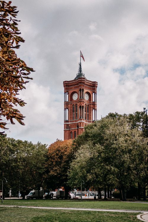 Free Low-angle view of the Rotes Rathaus tower in Berlin, Germany, framed by autumn trees. Stock Photo