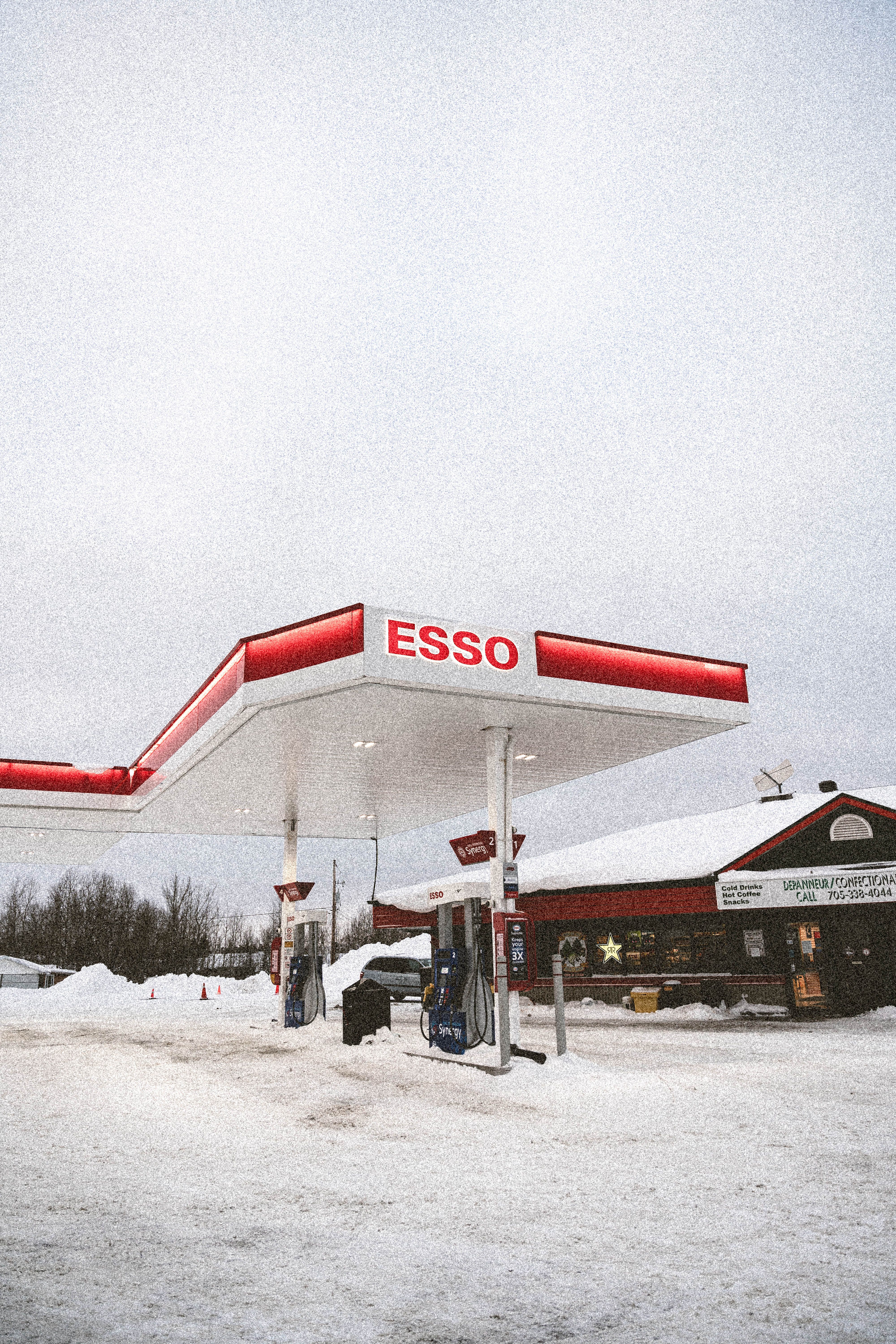 A snowy Esso gas station in a winter setting, showcasing a serene, cold environment with white surroundings.