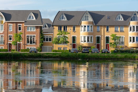 Symmetrical view of stylish residential buildings along a tranquil river in Voorschoten, Netherlands.