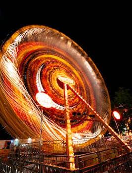 这张充满活力的长曝光照片拍摄的是夜间游乐园里旋转的照明旋转木马