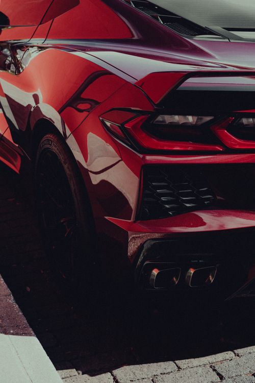 Free Close-up of a luxurious red sports car emphasizing its modern design and spoiler. Stock Photo