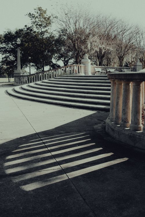 Free Elegant concrete stairs with dramatic baluster shadows in a peaceful park setting. Stock Photo
