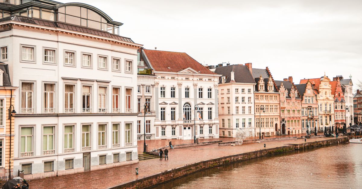 Medieval guild houses on the Graslei quay reflected in the Leie river, in Ghent
