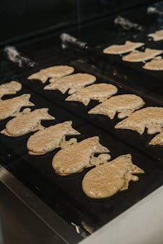 Freshly cooked taiyaki cakes on a traditional grill in a Japanese kitchen.