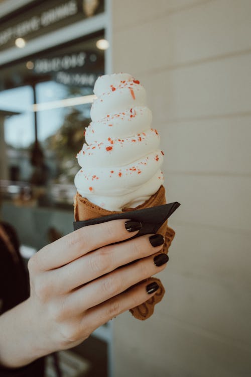 A Person with Black Nail Polish Holding an Ice Cream in Cone
