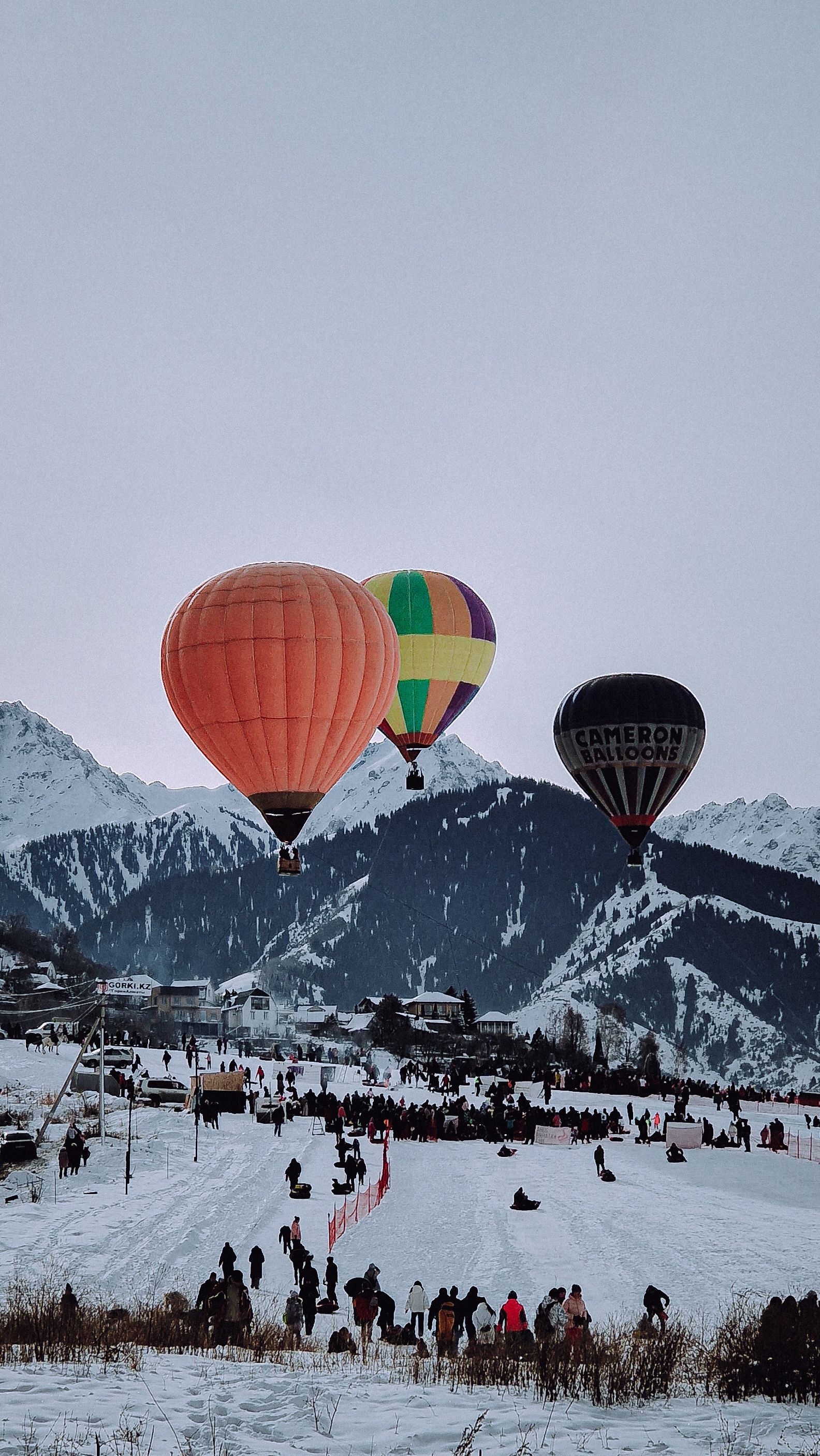 Colorful Hot Air Balloons over a Snowy Mountain Valley · Free Stock Photo