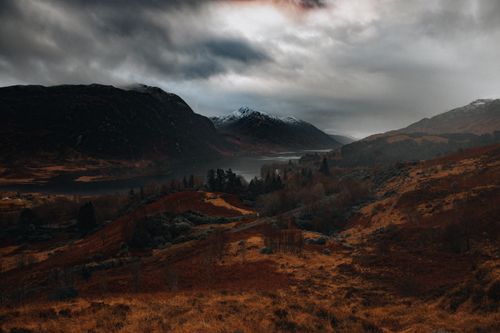 Free A stunning aerial landscape shot of hills and a river under an overcast winter sky. Stock Photo