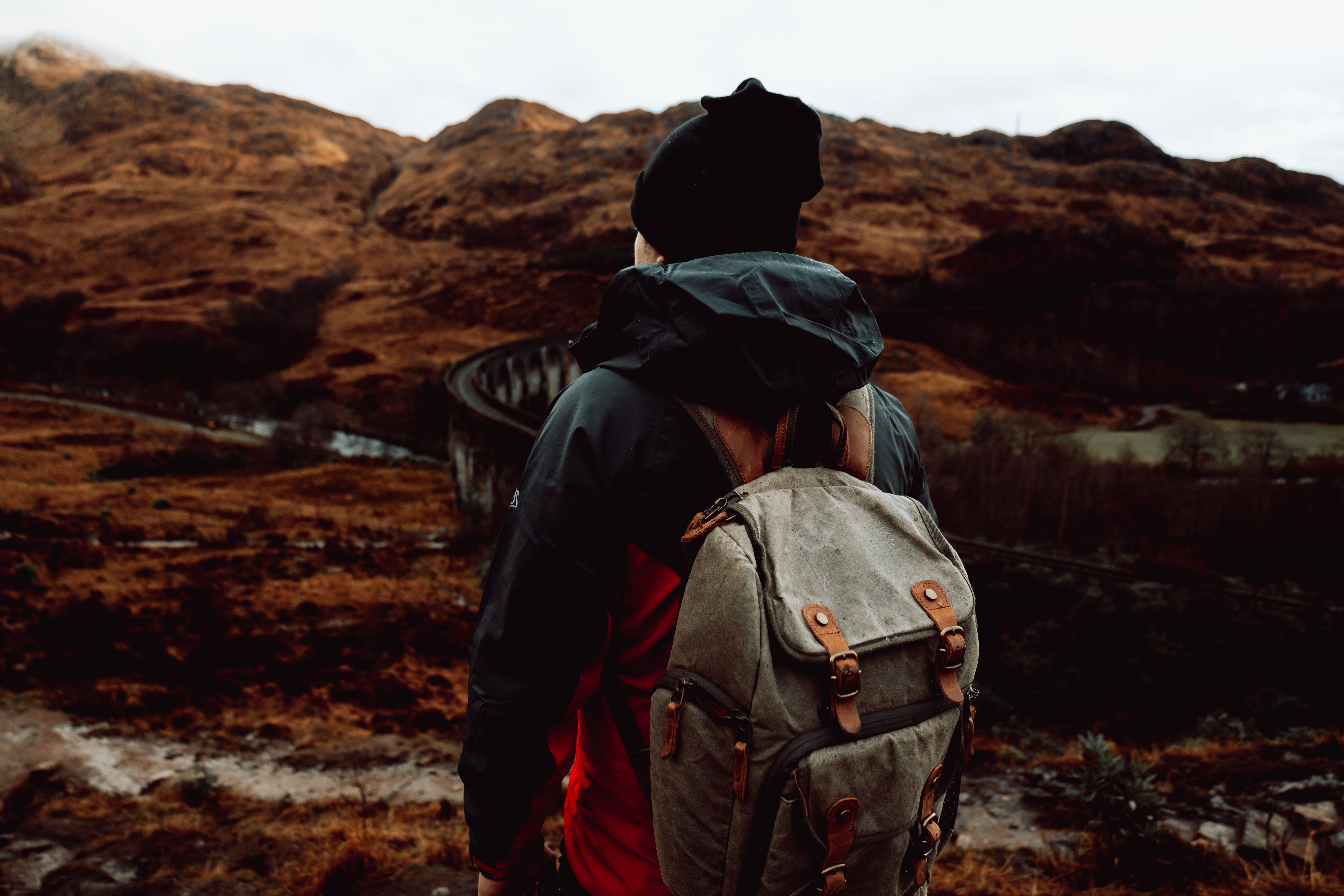 Person in Jacket Standing near Rocks · Free Stock Photo