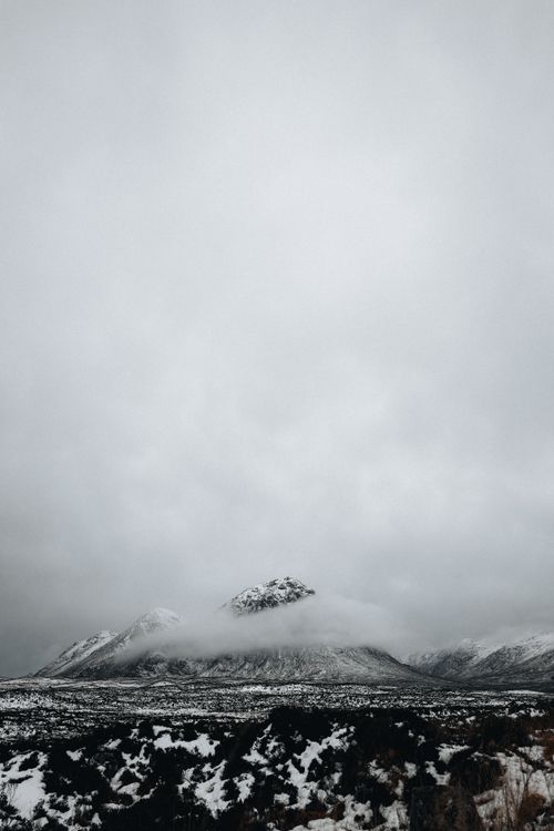 Free Dramatic snowy mountain landscape with overcast sky, capturing winter serenity. Stock Photo