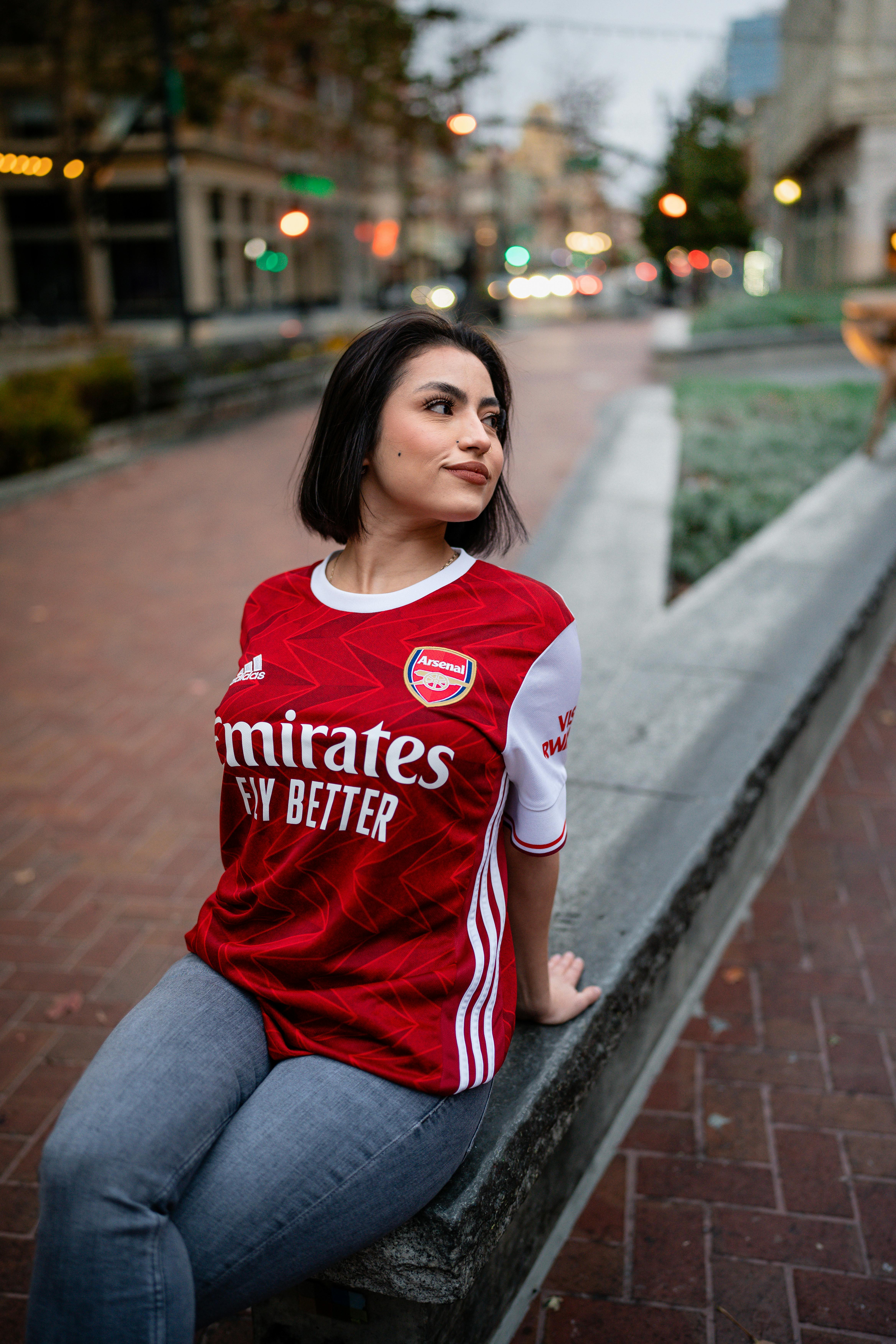 woman in football uniform posing on city street