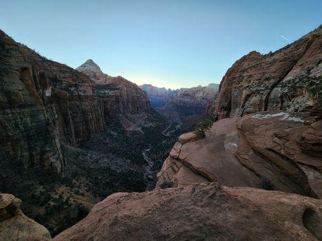 Expansive view of a canyon during sunrise, showcasing stunning geological formations.