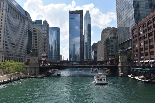 Free Stunning view of Chicago River flanked by towering skyscrapers and boats on a sunny day. Stock Photo