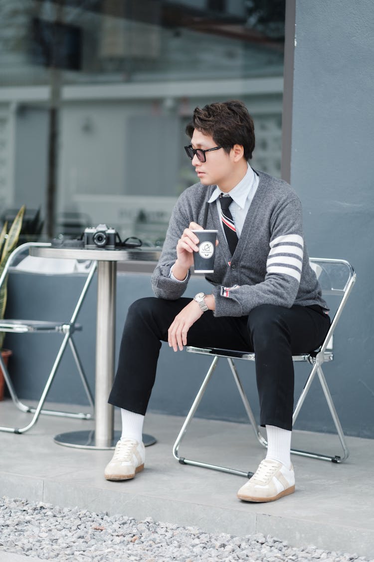 Man Sitting Near Table With Camera