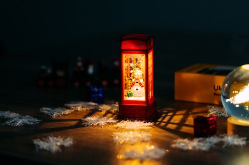 Free A festive Christmas scene with a snowman in a lit telephone booth ornament. Stock Photo