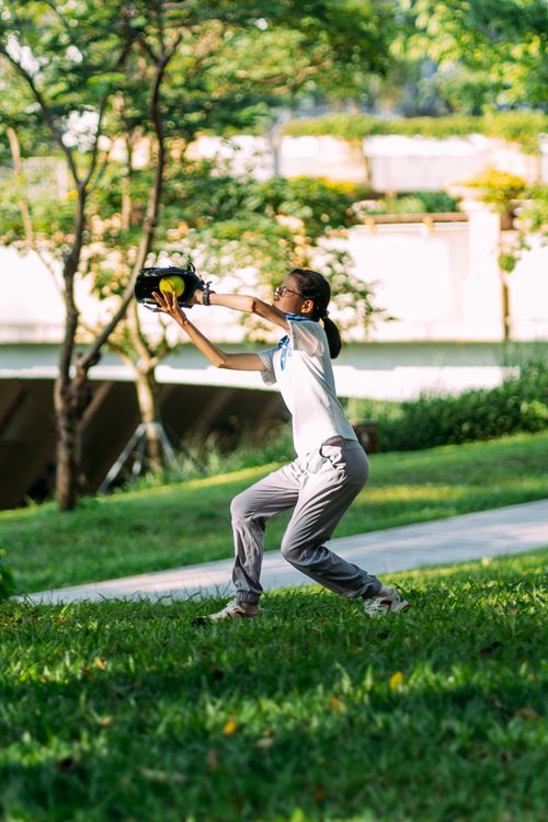 Free A young girl catching a baseball outdoors in a sunny park. Stock Photo