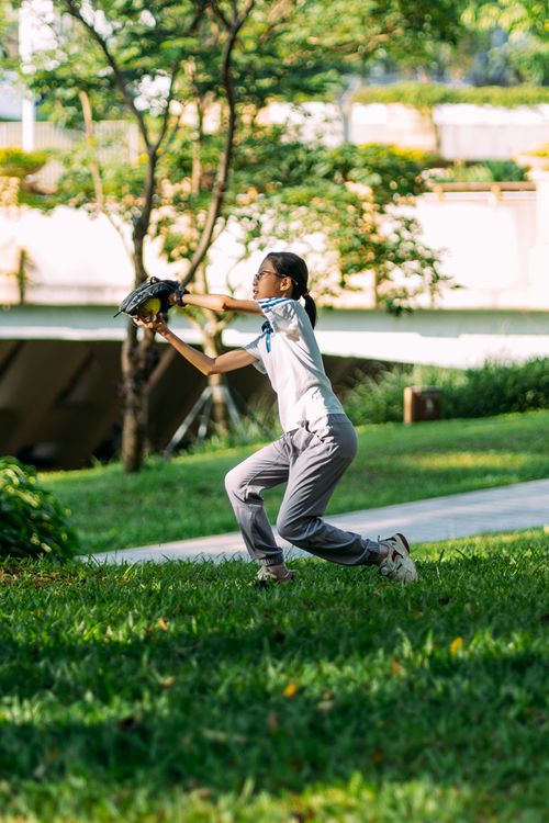 Free A girl catching a baseball in a park on a sunny day, showcasing fun and athleticism. Stock Photo