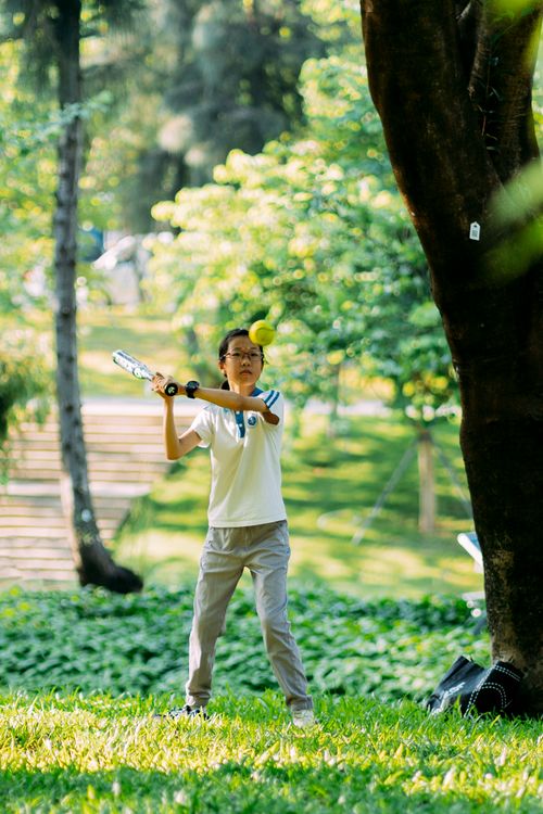 Free Young boy enjoying a summer day playing baseball in a sunny park. Stock Photo