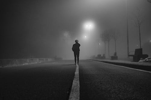 Silhouette of a Man Standing on the Road