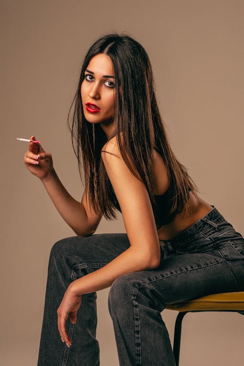 Foto profissional grátis de cabelo comprido, cadeira, cigarro